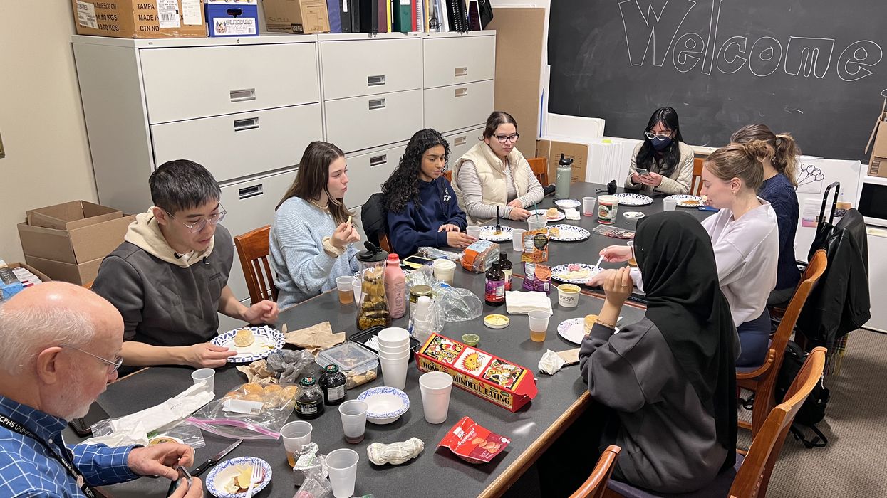 Students sitting at a table in a classroom.