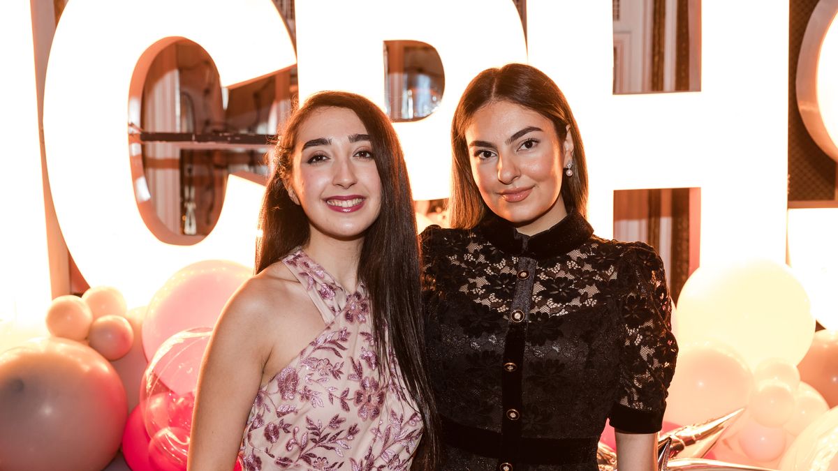 Two women pose in front of the MCPHS sign at Reunion 2024.