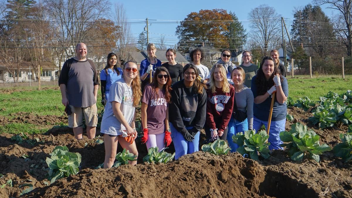 The Health Care Advocates for Sustainability smile for a photo in the NH Food Bank production garden.