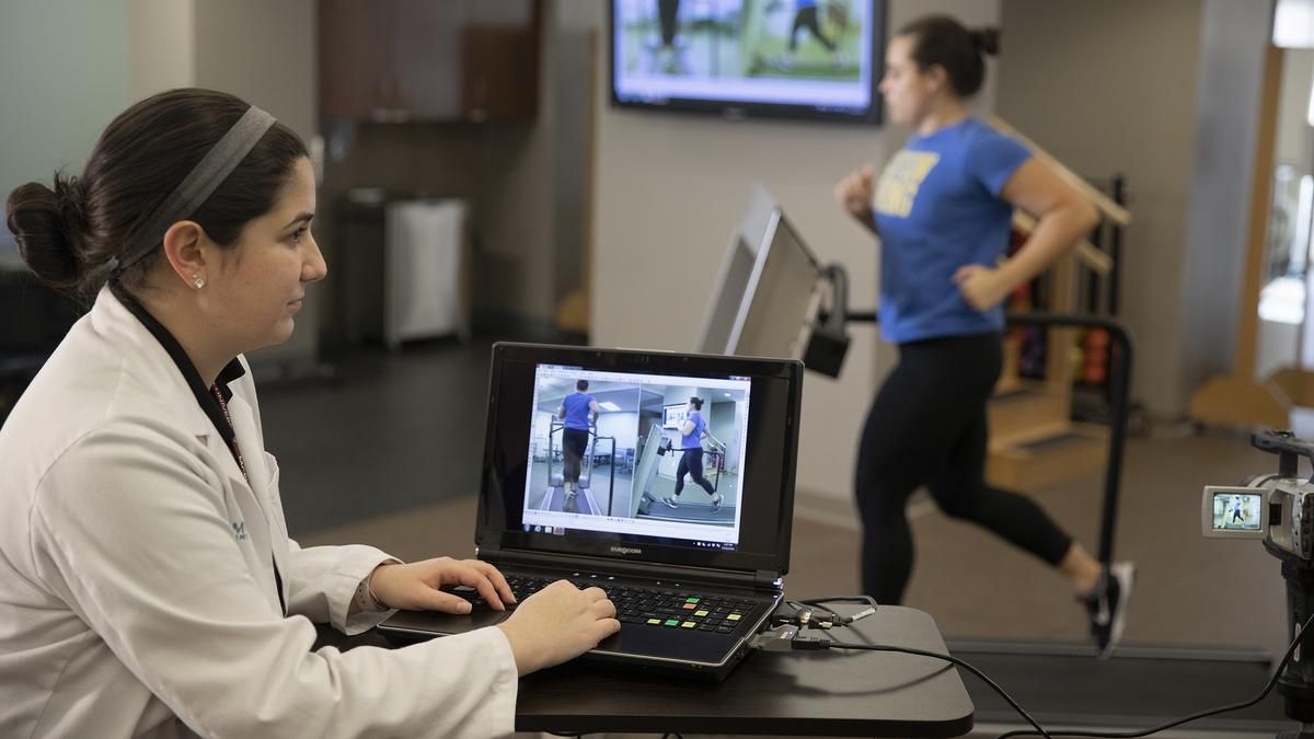 MCPHS physical therapy student monitoring a running patient's progress through her laptop