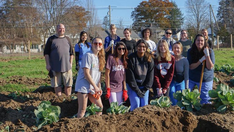 The Health Care Advocates for Sustainability smile for a photo in the NH Food Bank production garden.