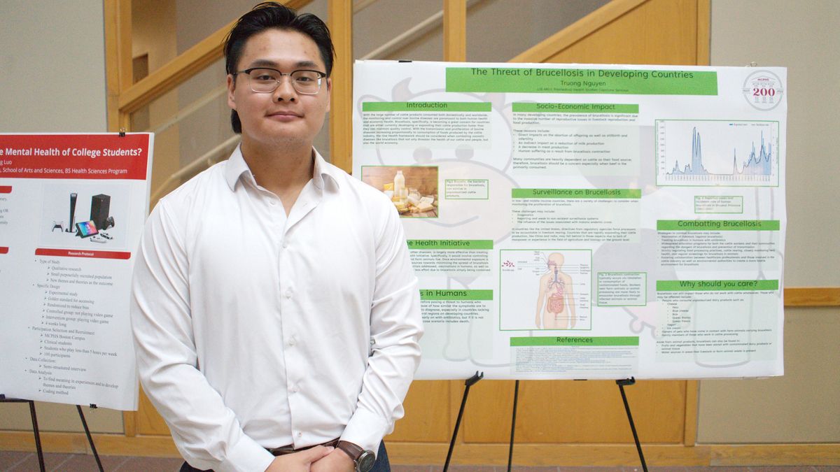 Truong Nguyen standing in front of a poster. 