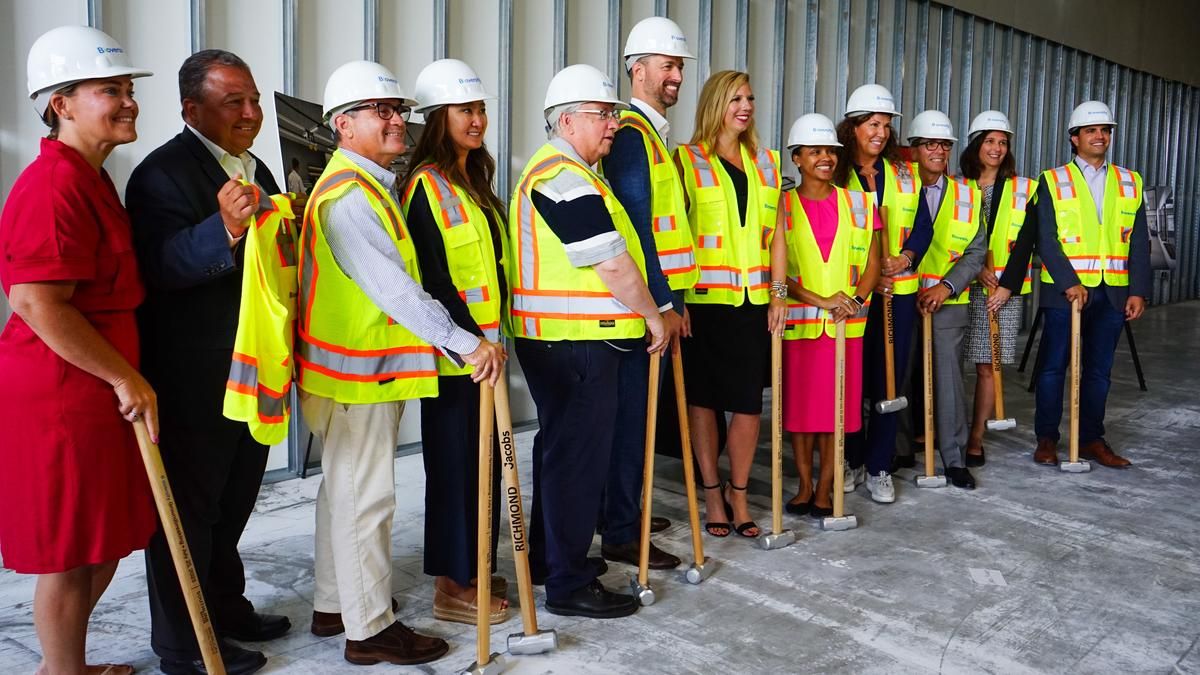 People posing with hard hats and sledgehammers