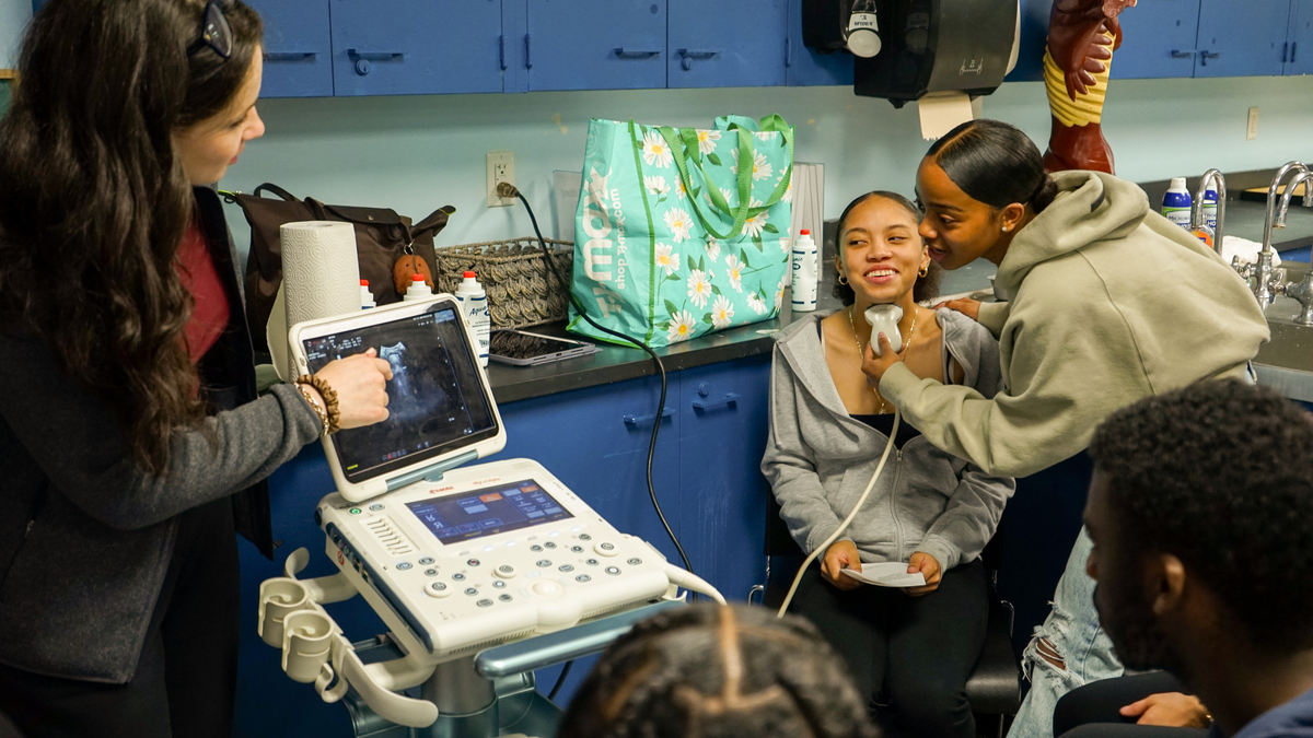 Students using an ultrasound machine to see the anatomy of the throat.