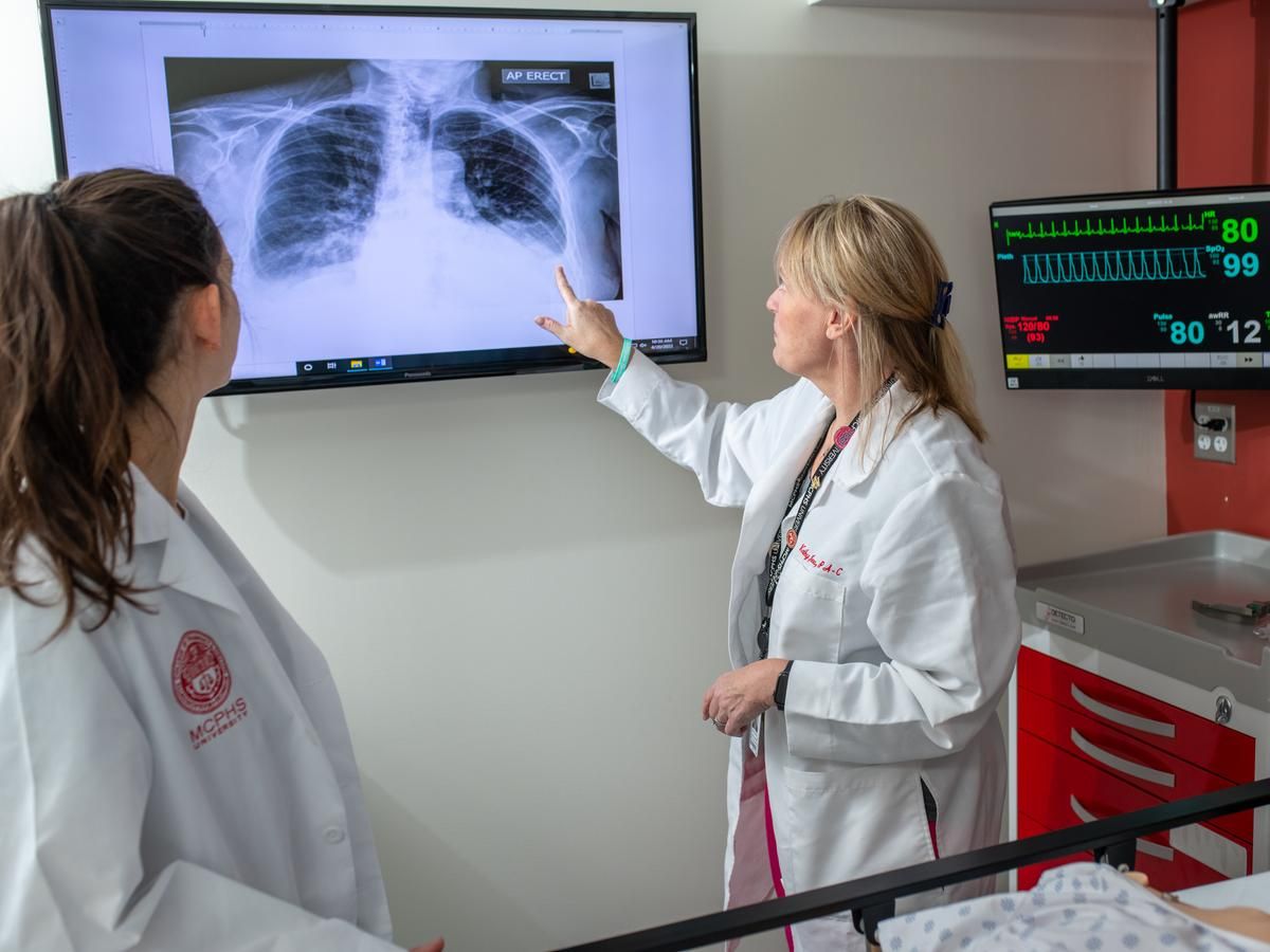 PA student and faculty looking at an x-ray.