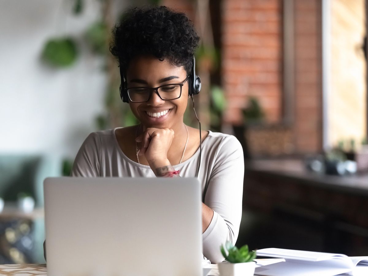 Woman in front of laptop with headphones. 